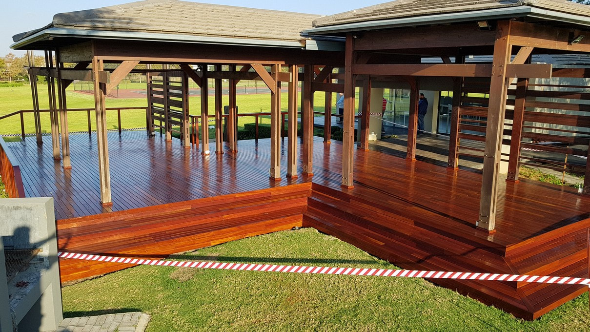 Men are observing a red ironbark clubhouse decking at Lombardy Estate, Pretoria.